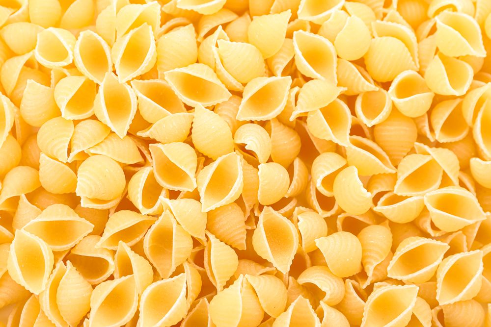 Pasta as background, closeup. Uncooked whole wheat pasta
