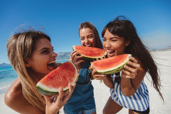 Cheerful female models laughing with watermelon slices