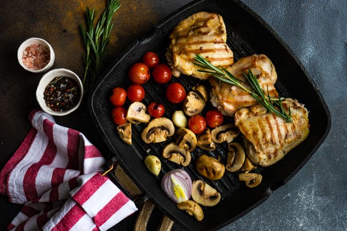 Top view of grilled chicken and vegetable on stone background