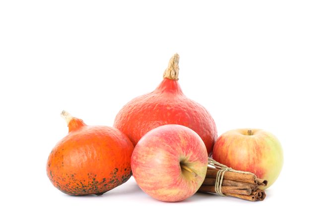 Pumpkins, apples and cinnamon isolated on plain background