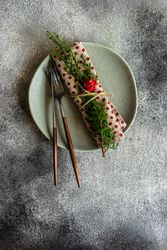 Top view of rustic table setting for Christmas dinner of dotted napkin with branch