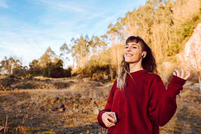 Young woman with smartphone dancing