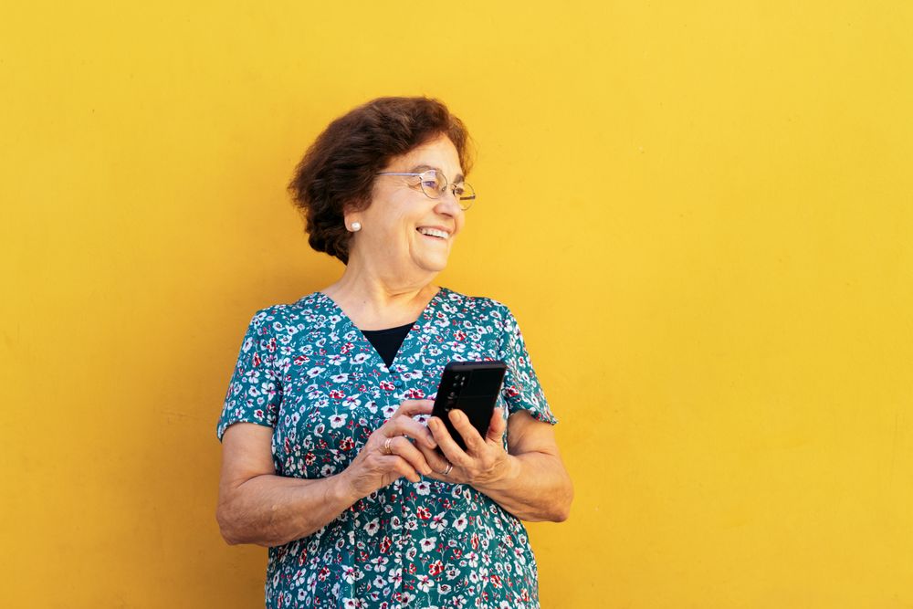 Smiling older woman using smartphone outdoors