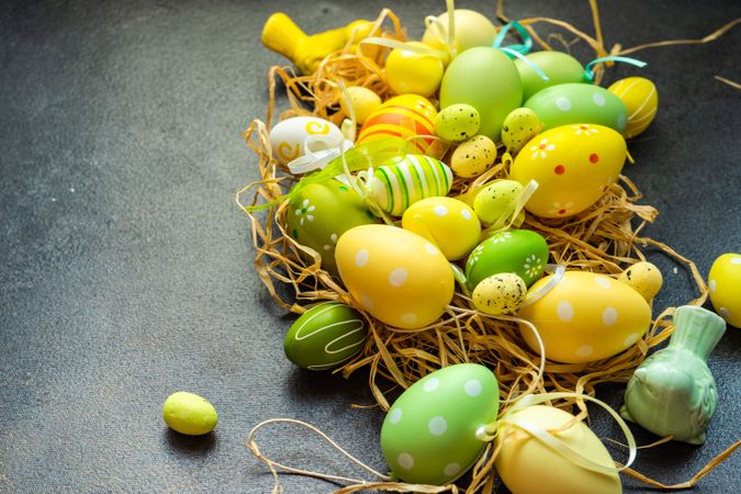 Colorful Easter decorations in straw on grey table