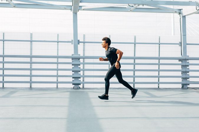 Man running on modern bridge in city