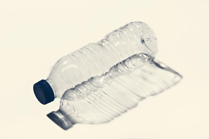 Empty small plastic bottle on white surface