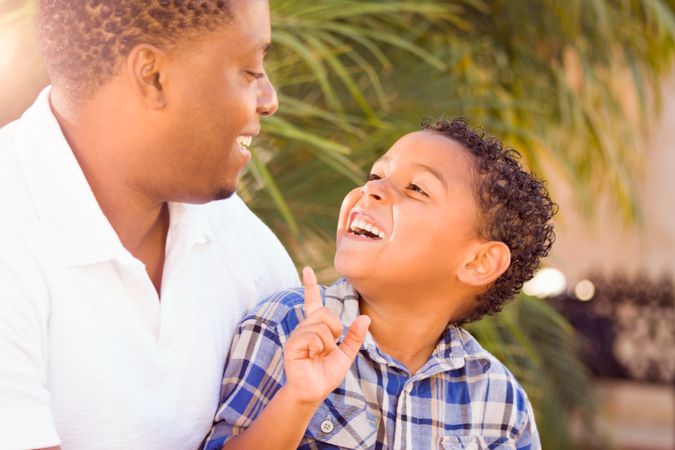 Black Father Talking With Son Outdoors