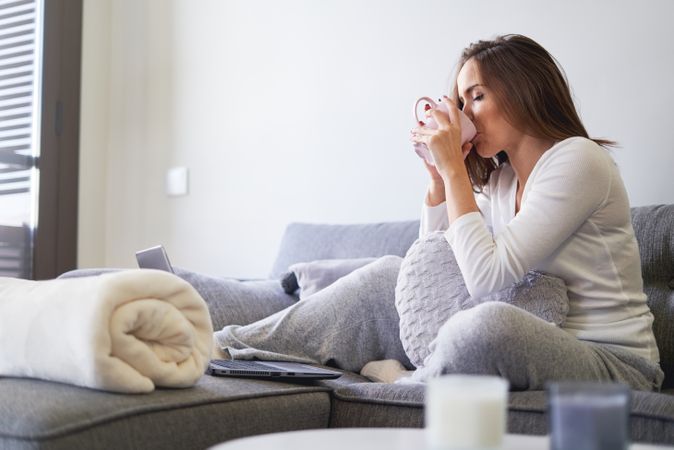 Woman drinking from cup in kitchen