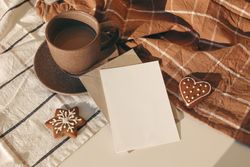 Cup of coffee, star and heart shaped gingerbread cookies on sunny checkered table cloth