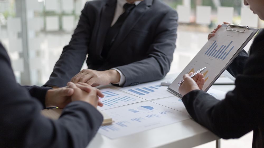 Business People Looking at Graphs in Meeting