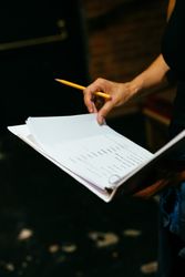 Close up of hand with pencil and script