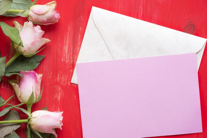 Message card on envelope and roses