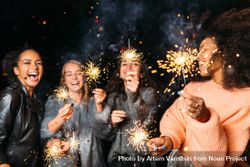 Multi-ethnic group of happy women at fun party with sparklers 41k6Z0
