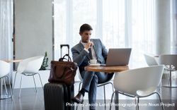 Businessman in airport business lounge with laptop 5r9qD1