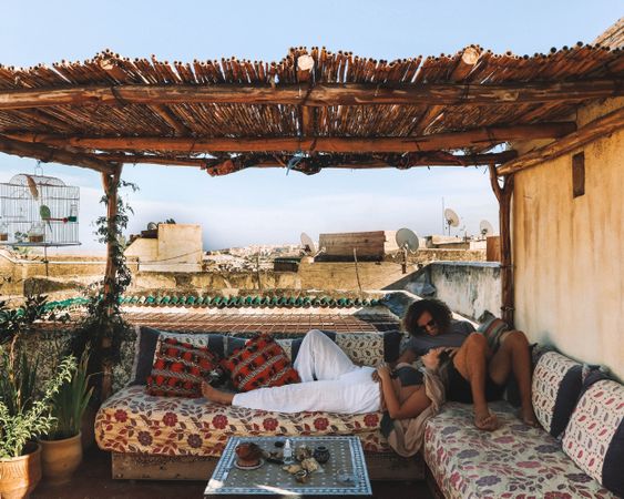 Man and woman lying on sofas outdoor on roof