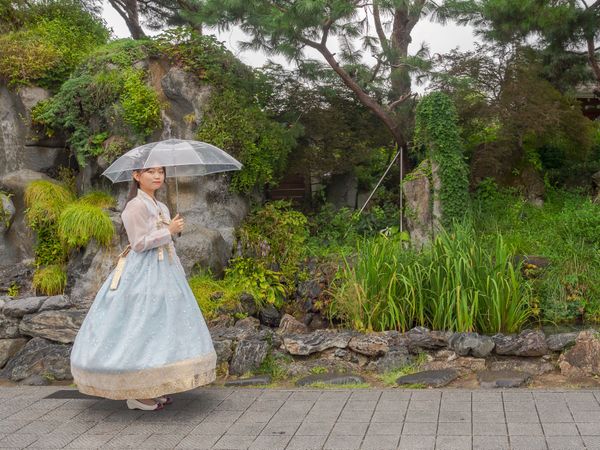 Seoul, South Korea - August, 08 2017: Asian woman in traditional clothes with umbrella