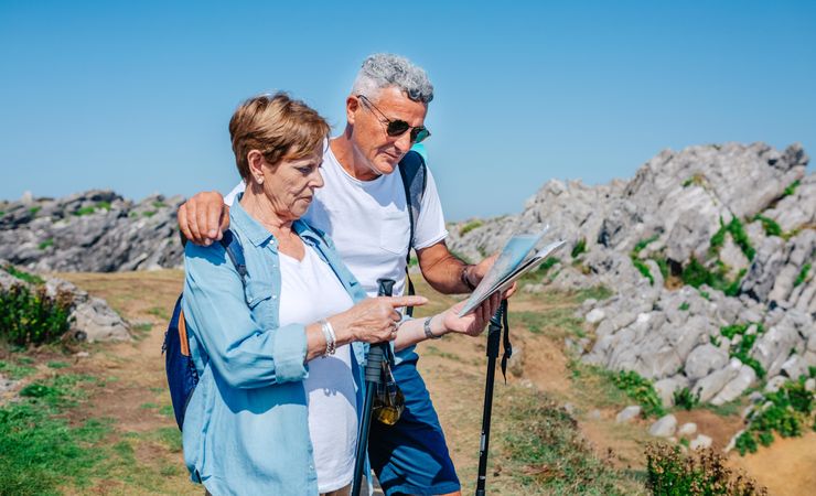 Older couple checking map during a trek standing together