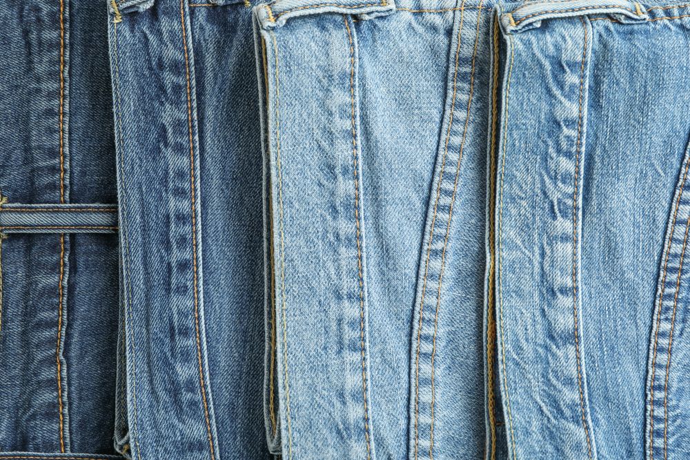 Jeans of different colors as background, space for text
