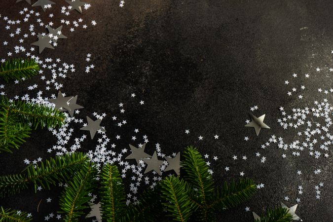 Christmas card concept of pine branches and star confetti with space for text