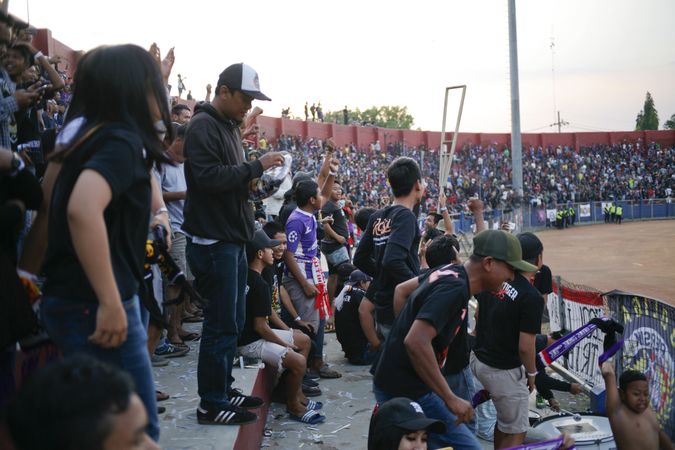 Kedira, East Java Indonesia - October 4, 2019: Fans standing in a soccer stadium cheering on a team