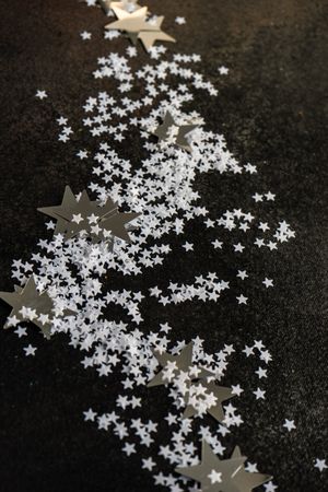 Christmas card concept of scattered star confetti on table