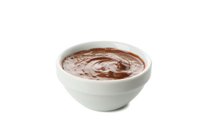 Bowl with melted chocolate isolated on plain background