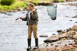 Female Fisherman Lifting Net from River