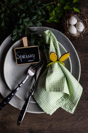 Spring table setting with green napkin in rabbit ring