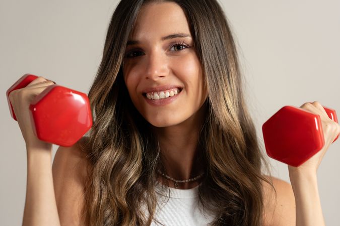 Young woman smiling dumbbells fitness workout healthy lifestyle exercise motivation wellness training sport