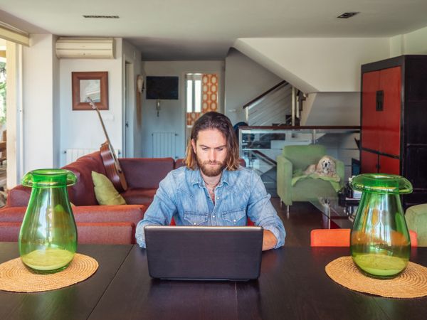 Focused man using computer in apartment