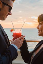 Young man and woman drinking juice from one glass