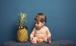 Happy baby playing with a pineapple