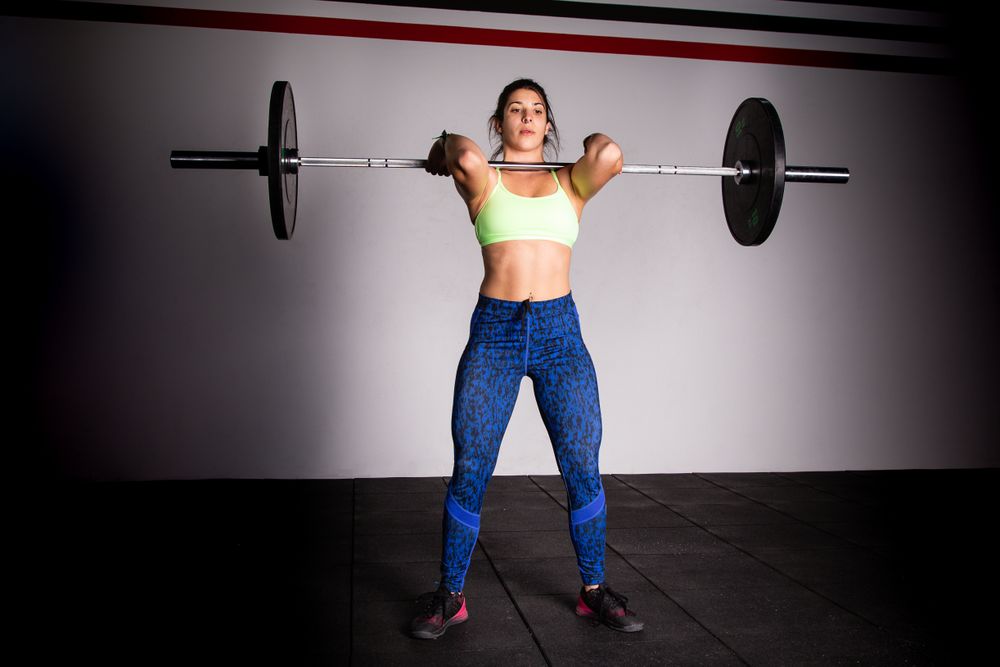Woman lifting barbell in gym