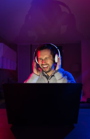 Man listening cheerfully to music with headphones.