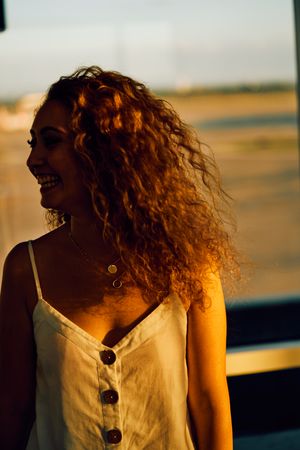 Smiling woman walking in spacious hall in sunlight