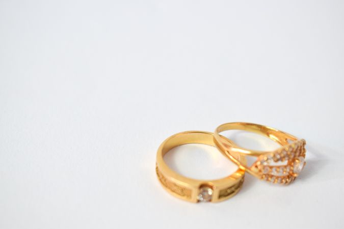 Two wedding diamond rings together on plain table with space for text