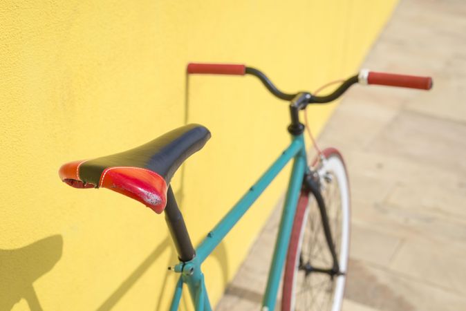 Bicycle outside next to bright yellow wall