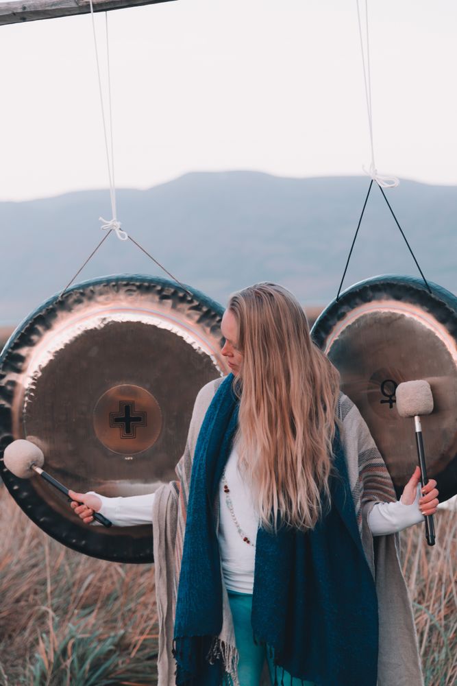 Woman near ethnic gongs on field