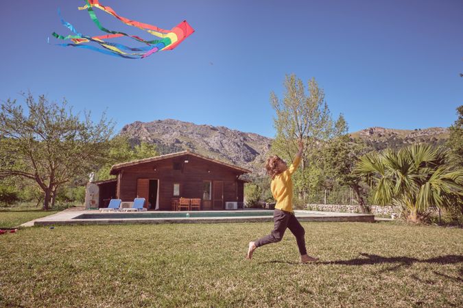 Happy boy running with paper kite