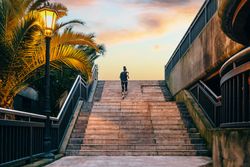 Female runner training on stairs at sunset