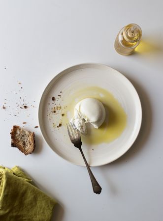 Plate with cheese near bread and condiments