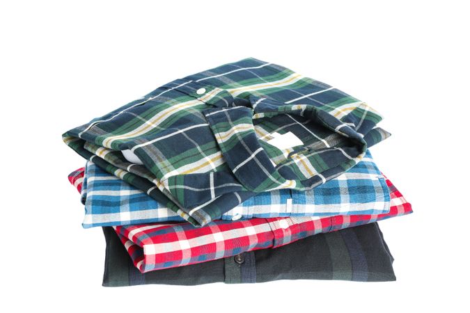 Stack of colorful shirts isolated on light background