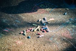 Colored chalk on pavement in sunny day