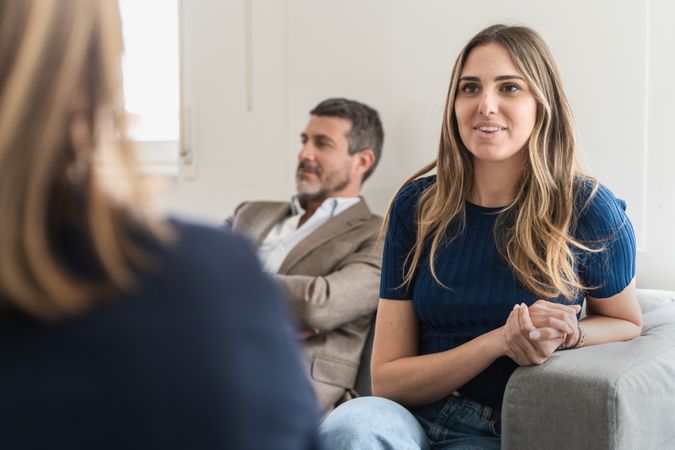 During a therapy session, a smiling wife actively communicates with the therapist