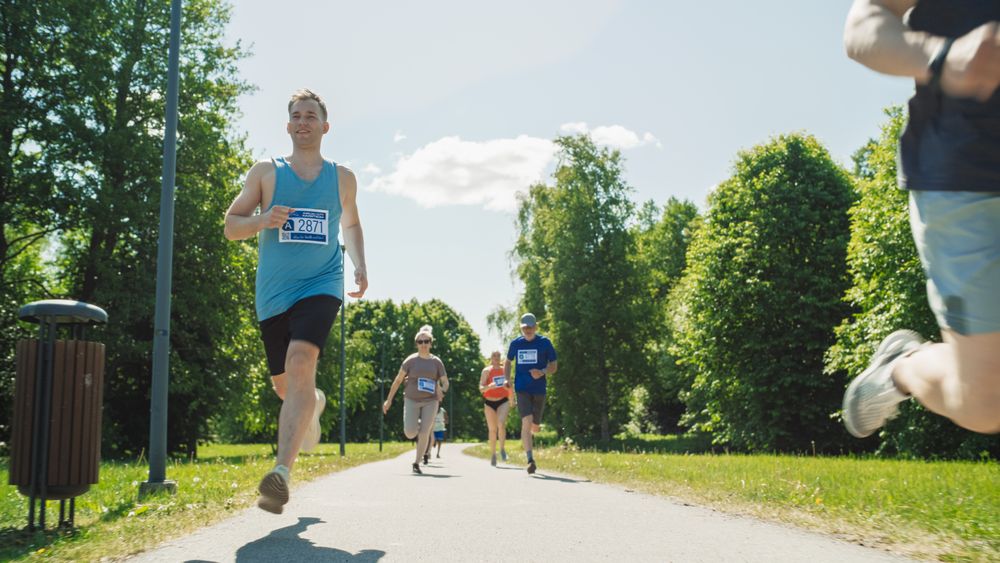 Portrait of a Diverse Group of People Participating in a Marathon and Running Through a Park Trail.