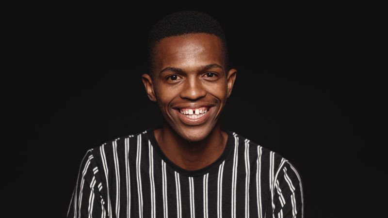 Close up portrait of smiling young man looking at camera