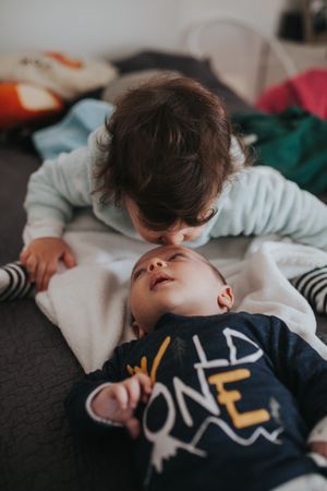 Toddler gives newborn sibling kisses
