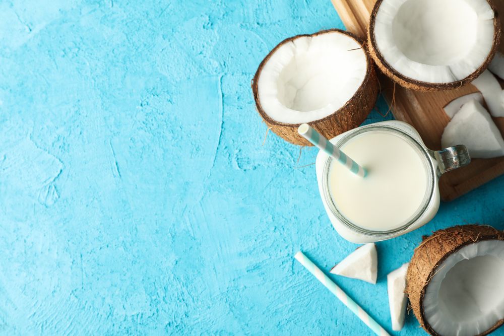 Coconut and milk on blue background, top view