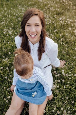 Mother and daughter sitting on lawn