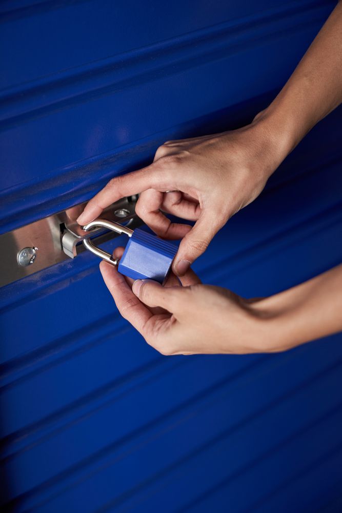 Nice woman's hands holding a blue padlock while closing it